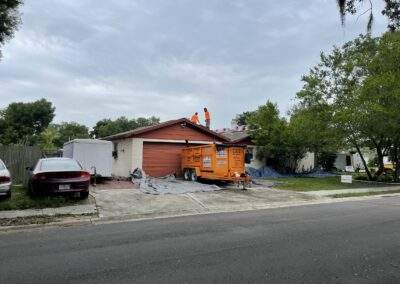 Brick home with a 'Giving Back' roofing project sign in the yard