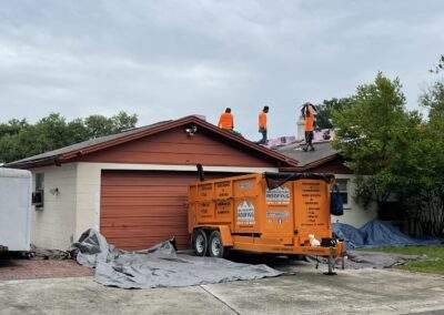 Roofing equipment trailer parked at a home during a community project