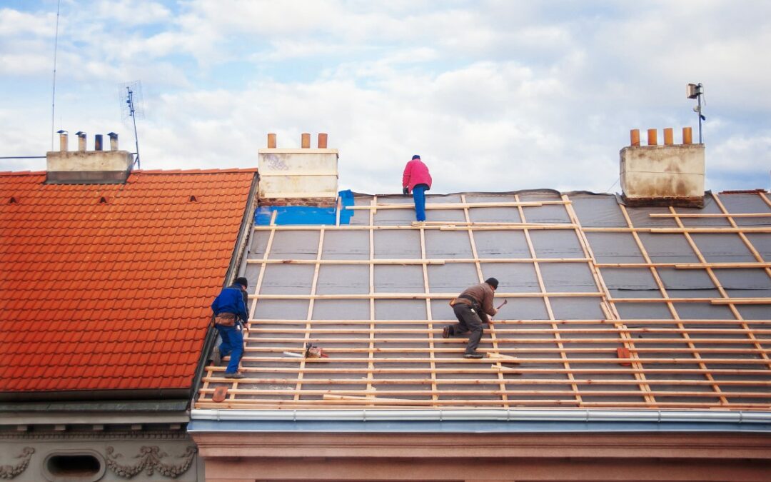 three builders replace the tiled roof in the old town